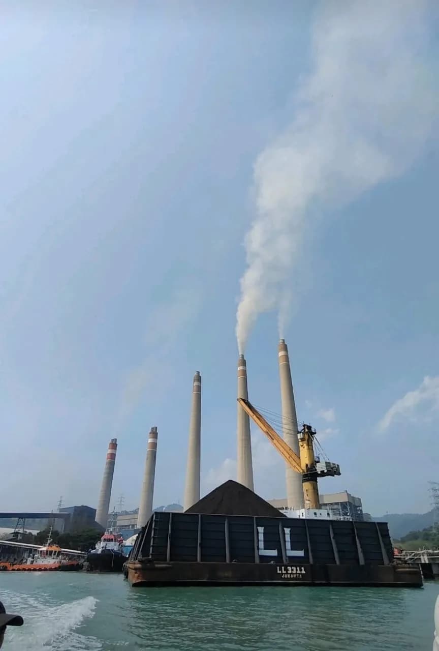 Loaded barge in front of industrial power facility